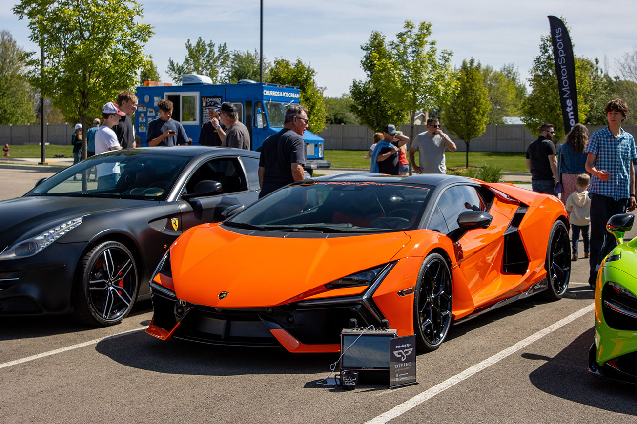 Orange Lamborghini on the modern and exotics field at Idaho Air 2026, between a Ferrari and a green McLaren